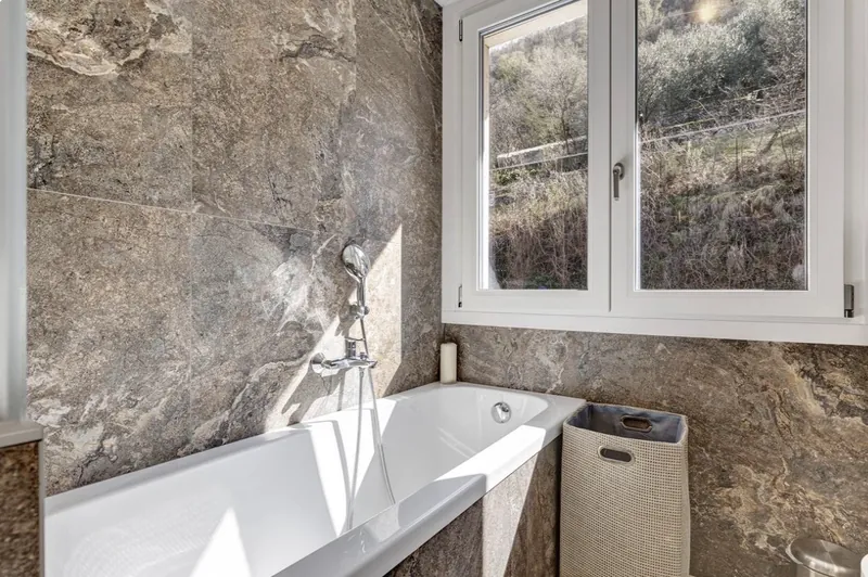 Badewanne am Fenster mit Blick in den Olivenhang